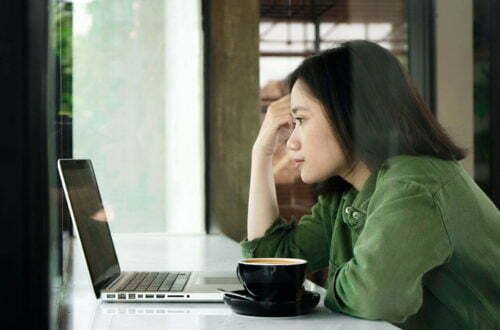 focused woman working on laptop online